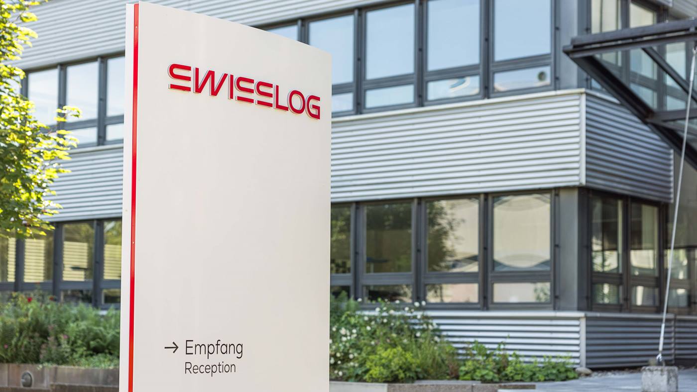 Swisslog headquarters building in Buchs, Switzerland with the new Swisslog logo and the KUKA logo