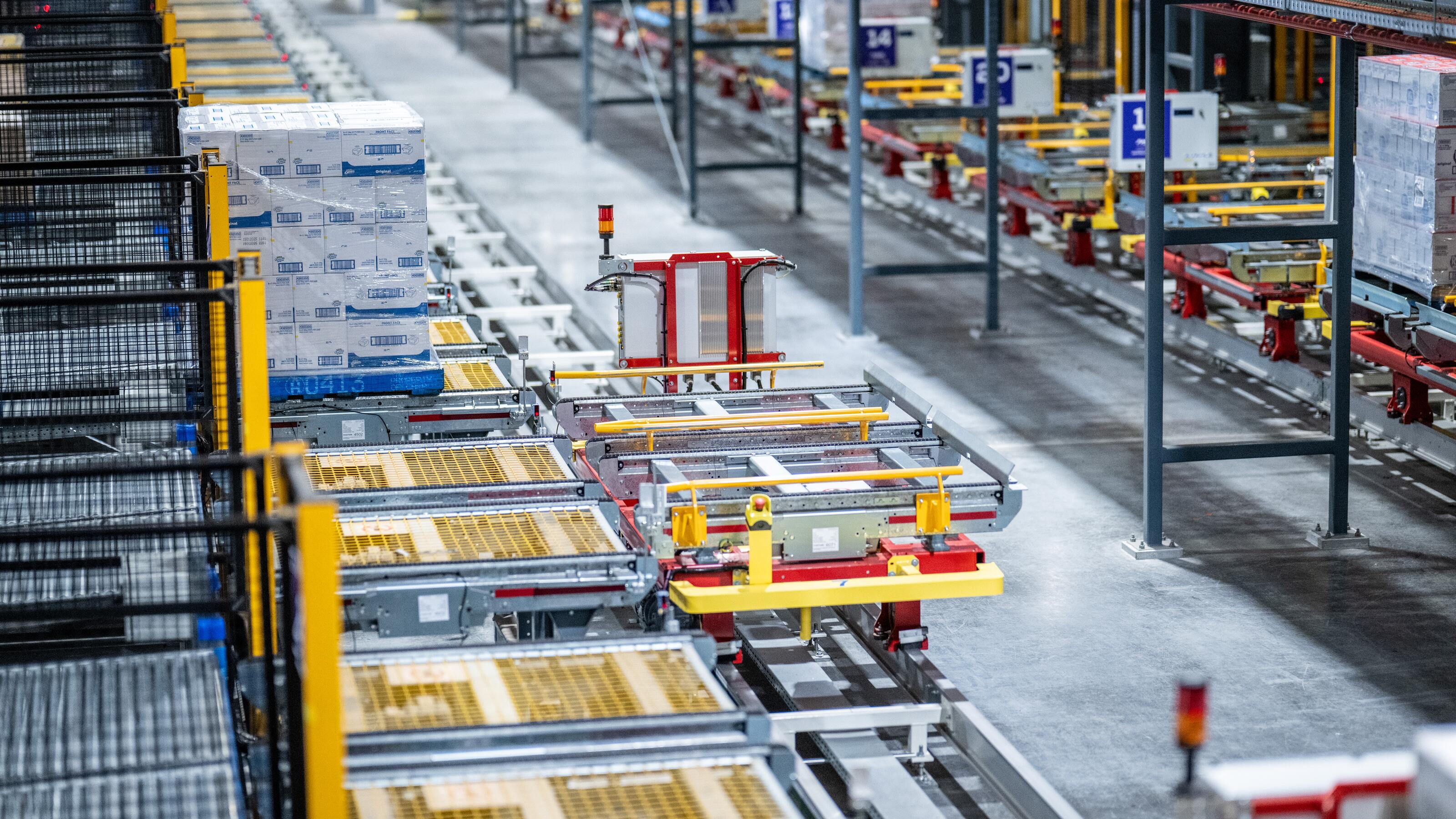 Automated monorail transport system moving pallets through a high-density warehouse distribution centre.