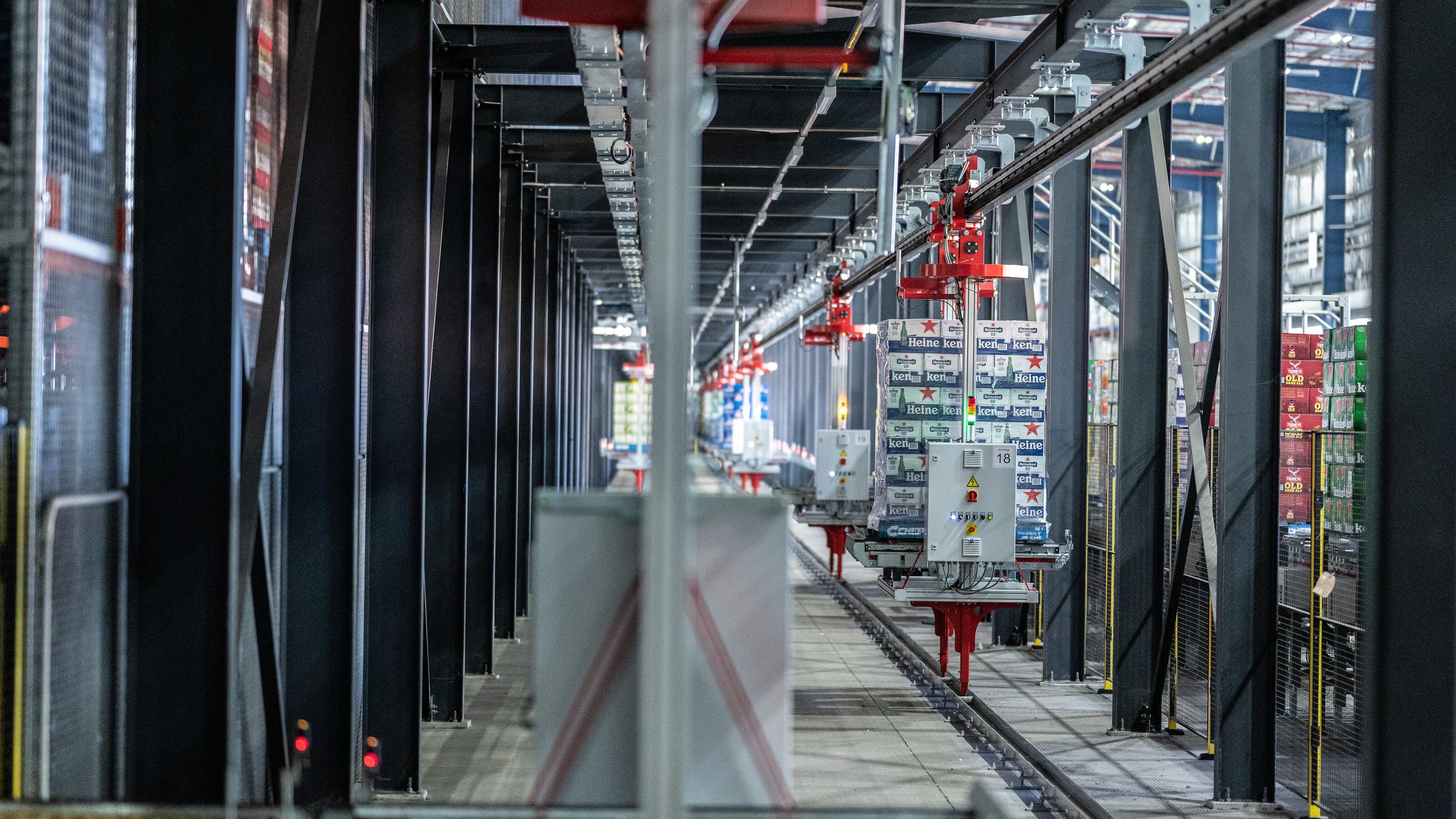 Automated monorail transport system moving pallets through a high-density warehouse distribution centre.