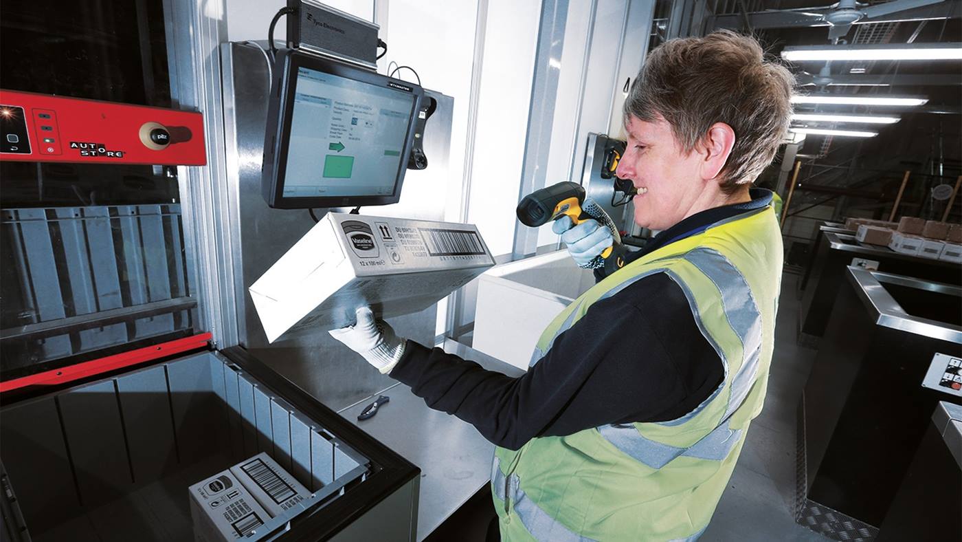 An Asda colleague working at a Swisslog AutoStore picking station