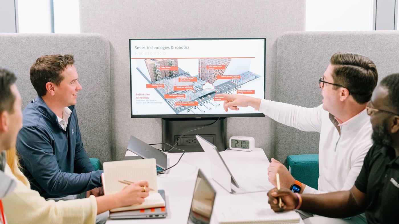 Automation specialists reviewing a warehouse automation system layout and technology portfolio.