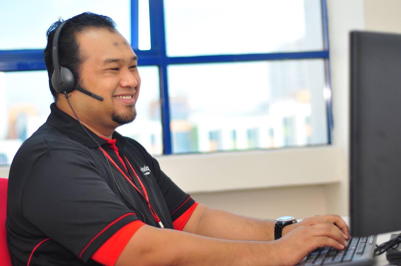 Swisslog customer service employee sat at a computer