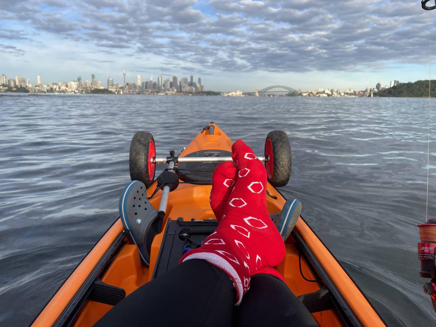 Swisslog colleague showing off his red socks in Sydney Harbour