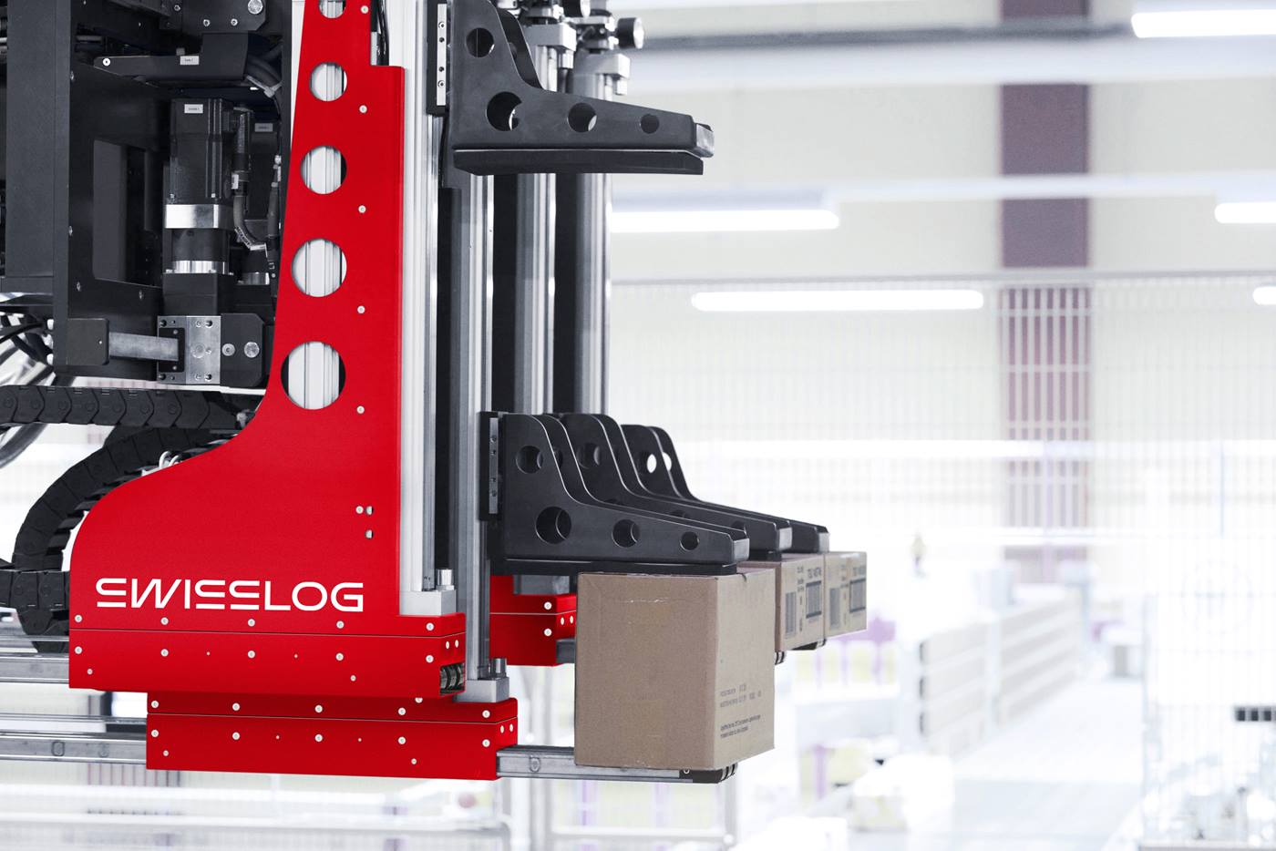 Brazo robótico automatizado de la solución ACPaQ de Swisslog realizando paletización de cajas mixtas en un almacén de fabricación de alimentos.