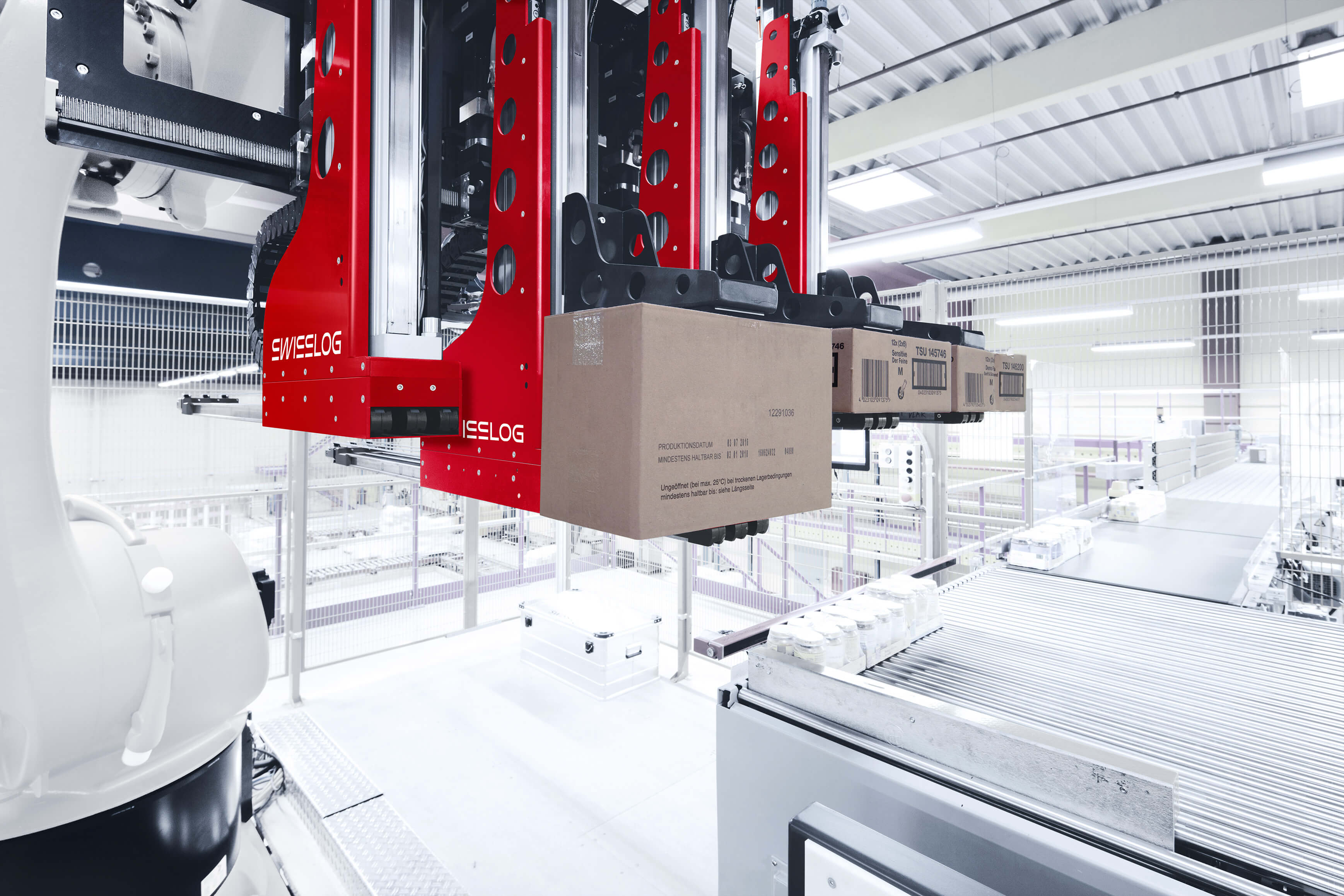 Automated robotic arm from Swisslog’s ACPaQ solution performing mixed case palletizing in a food manufacturing warehouse.